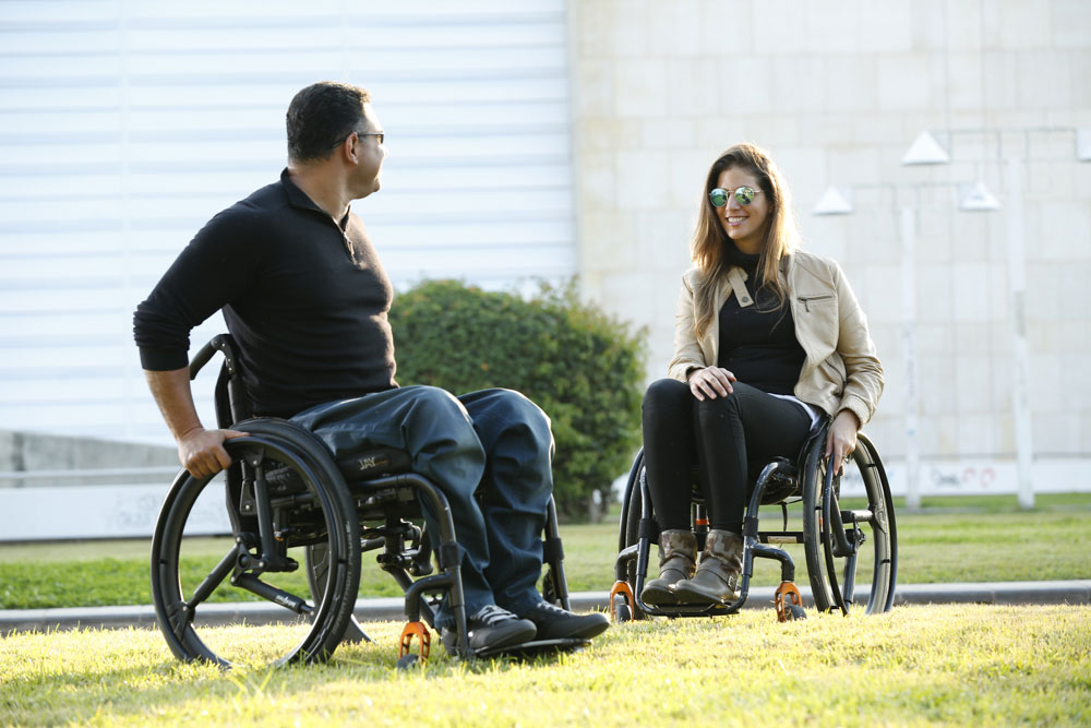 Man and woman on wheelchairs and SoftWheel wheels in the park