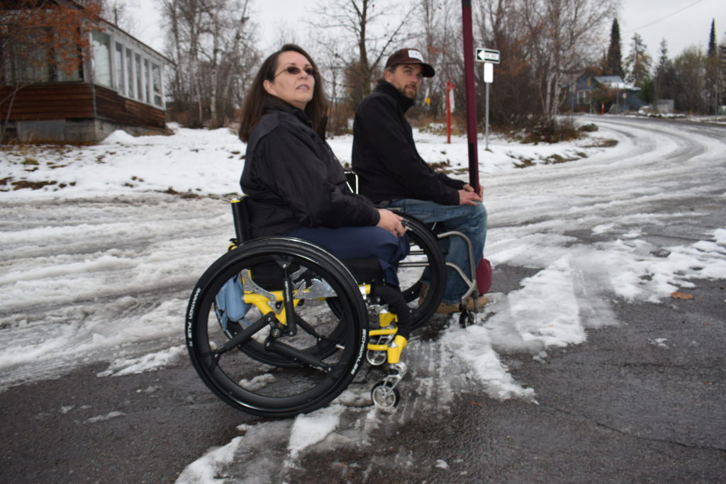 A man and a woman with wheelchairs and SoftWheel wheels on the snowy road