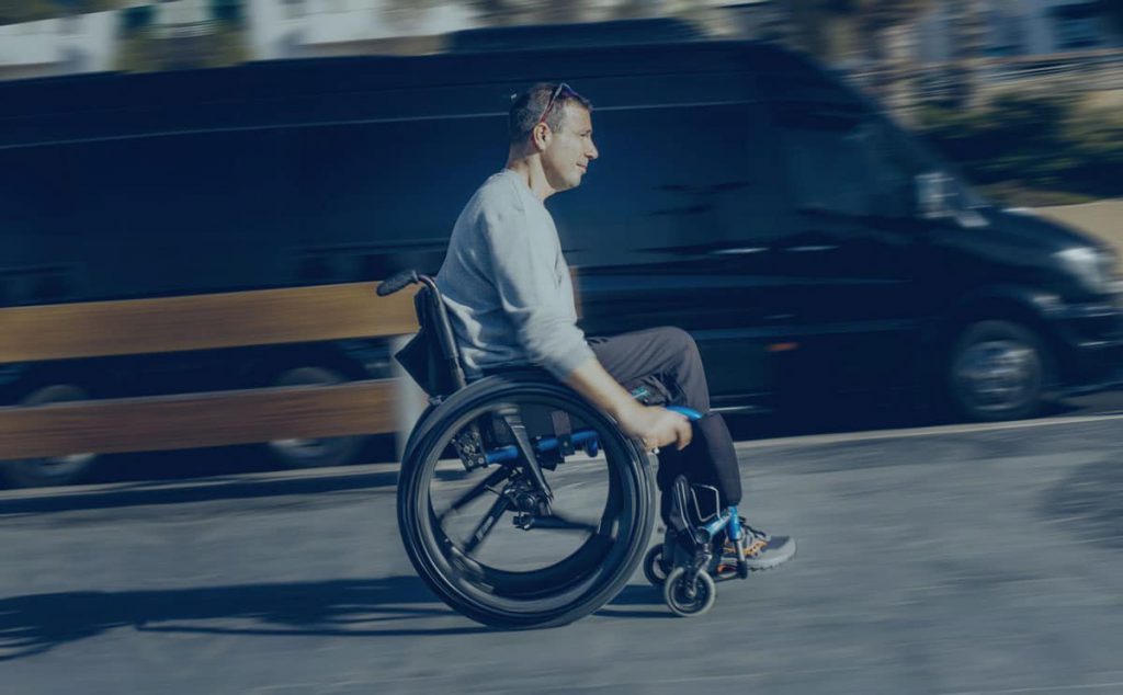 Man riding on wheelchair with SoftWheel wheels